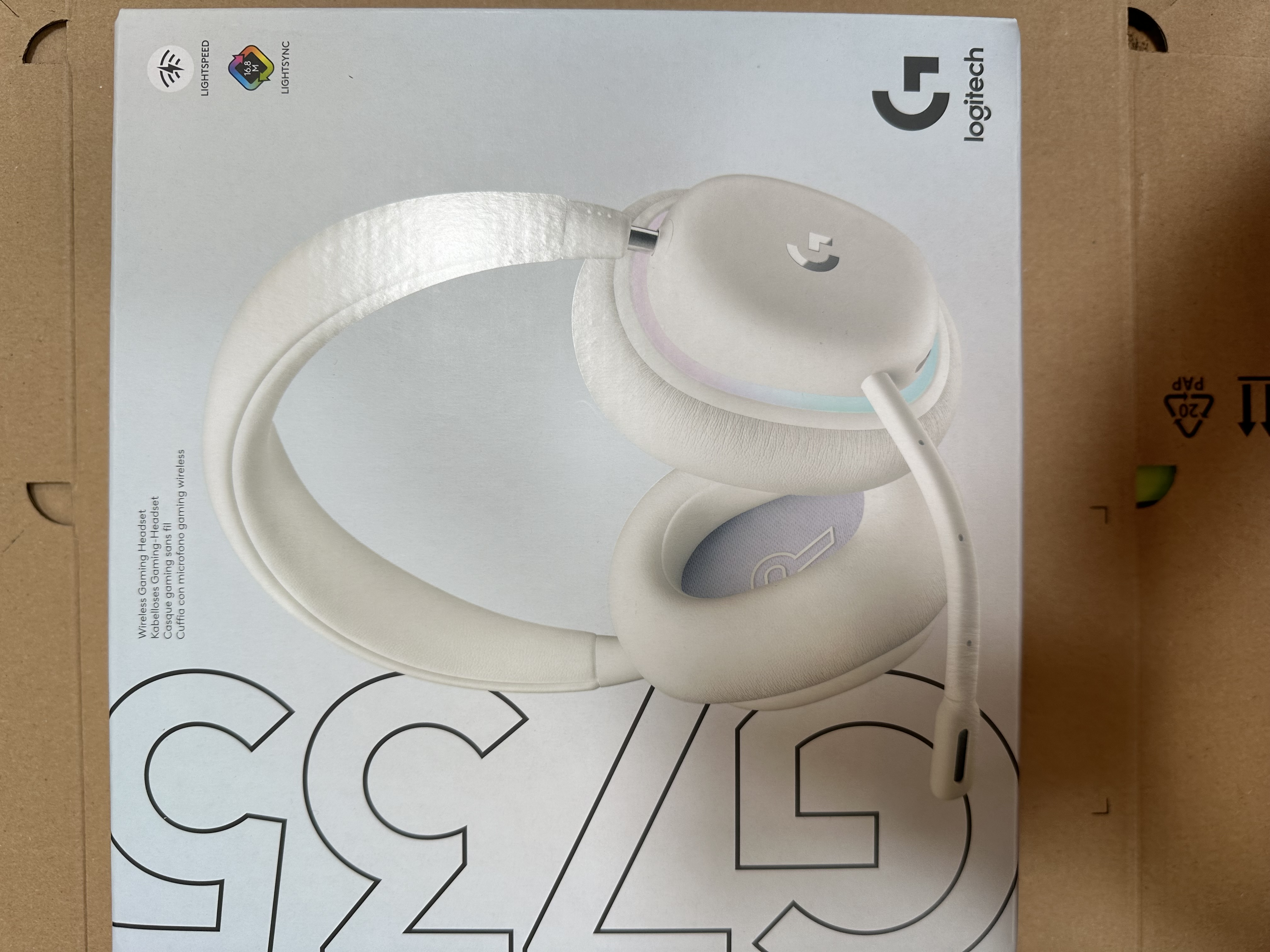 Pudełko słuchawek Logitech G735. Białe pudełko. Biała grafika słuchawek. Kolorowe akcenty. Białe tło.