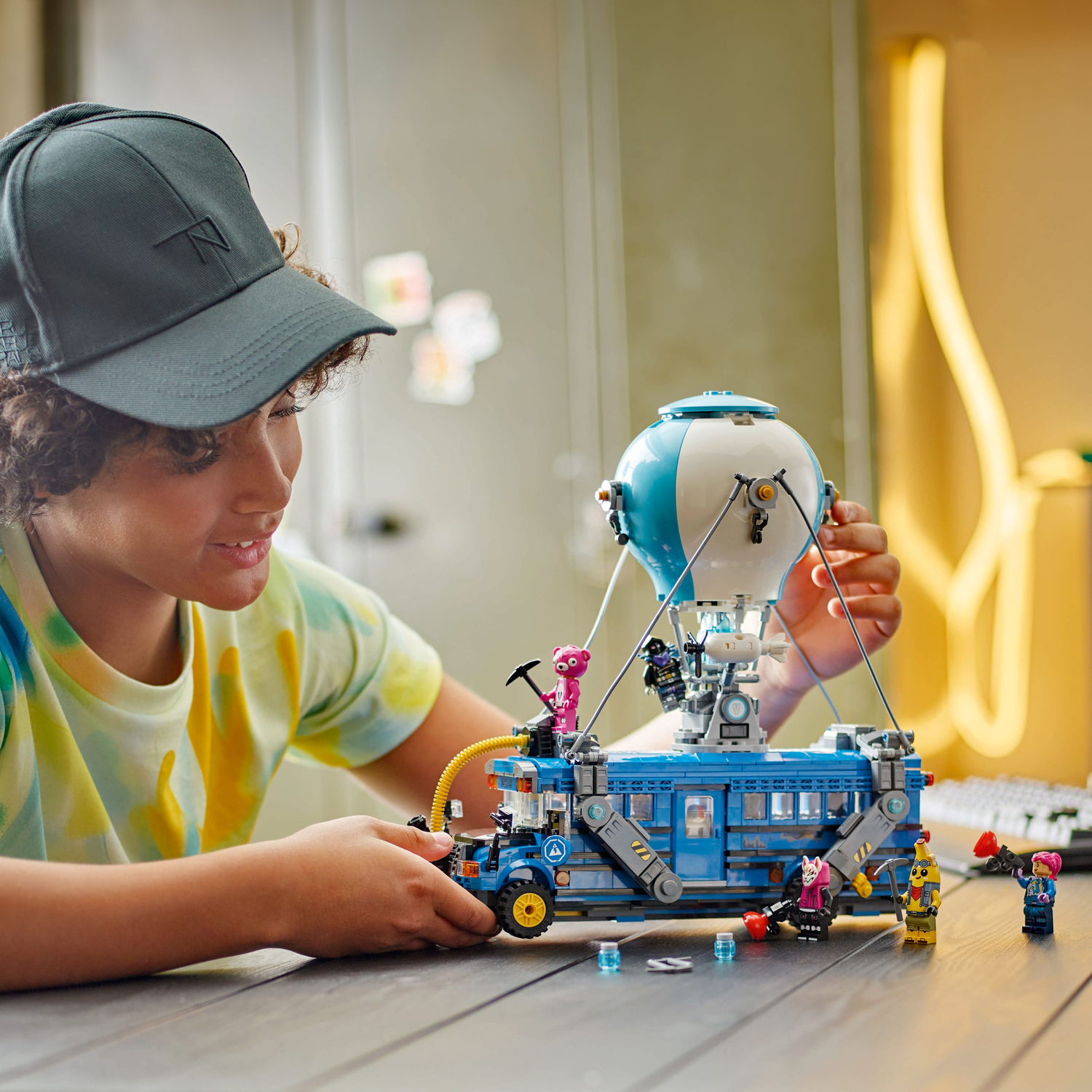Een persoon die de Lego Fortnite Battle Bus in elkaar zet. Blauwe bus, witte ballon.