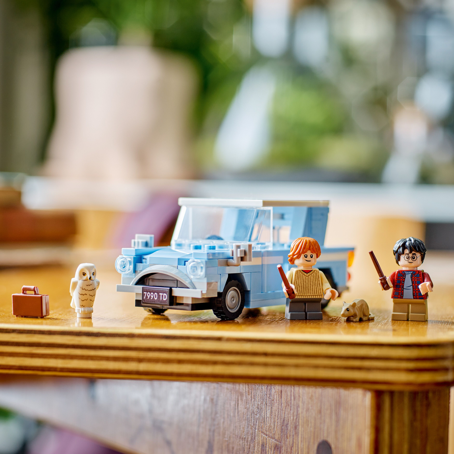 Lego scene: Blue car, Harry Potter, Ron, Hedwig, and a brown suitcase.