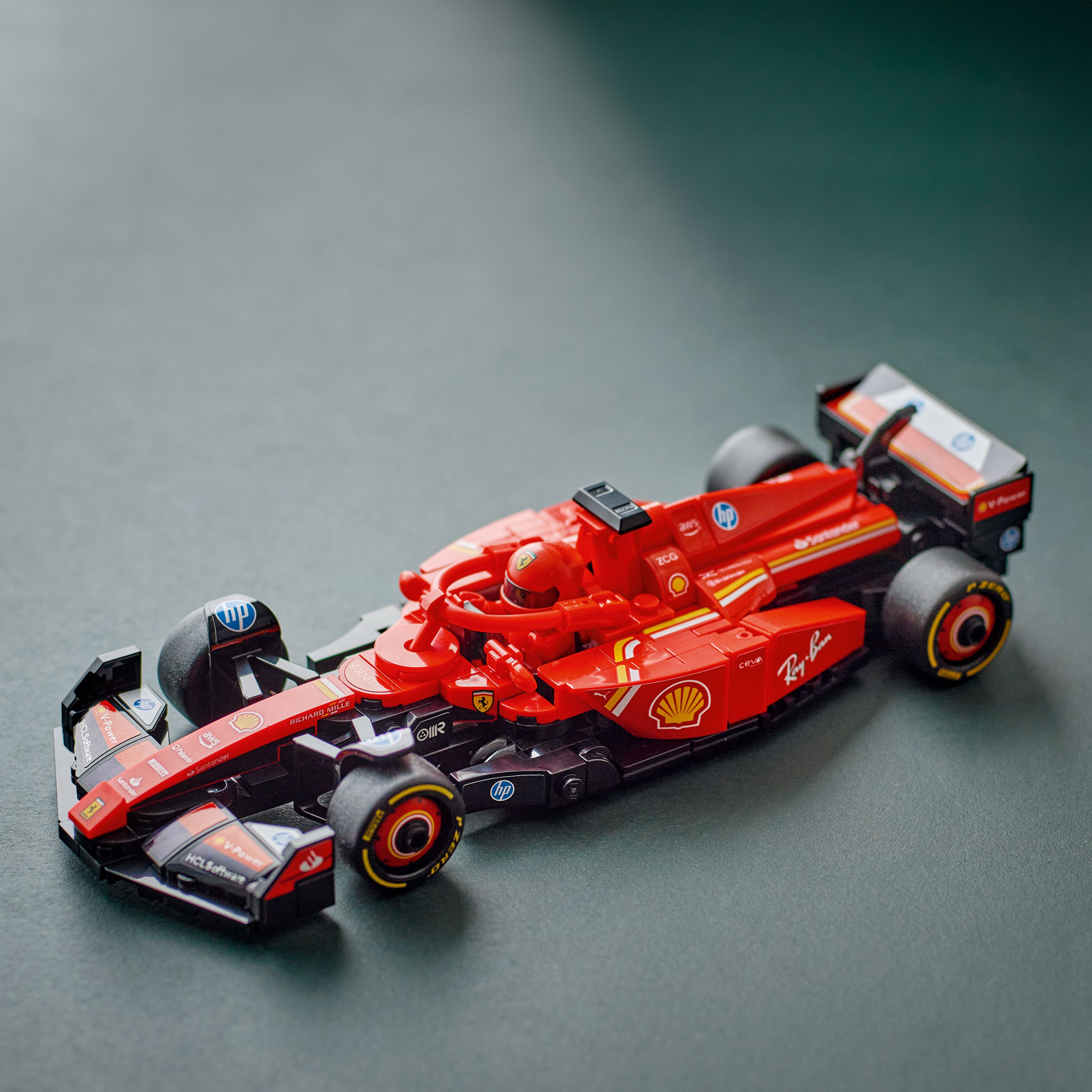 Red Ferrari F1 LEGO car on a dark green surface, top view.