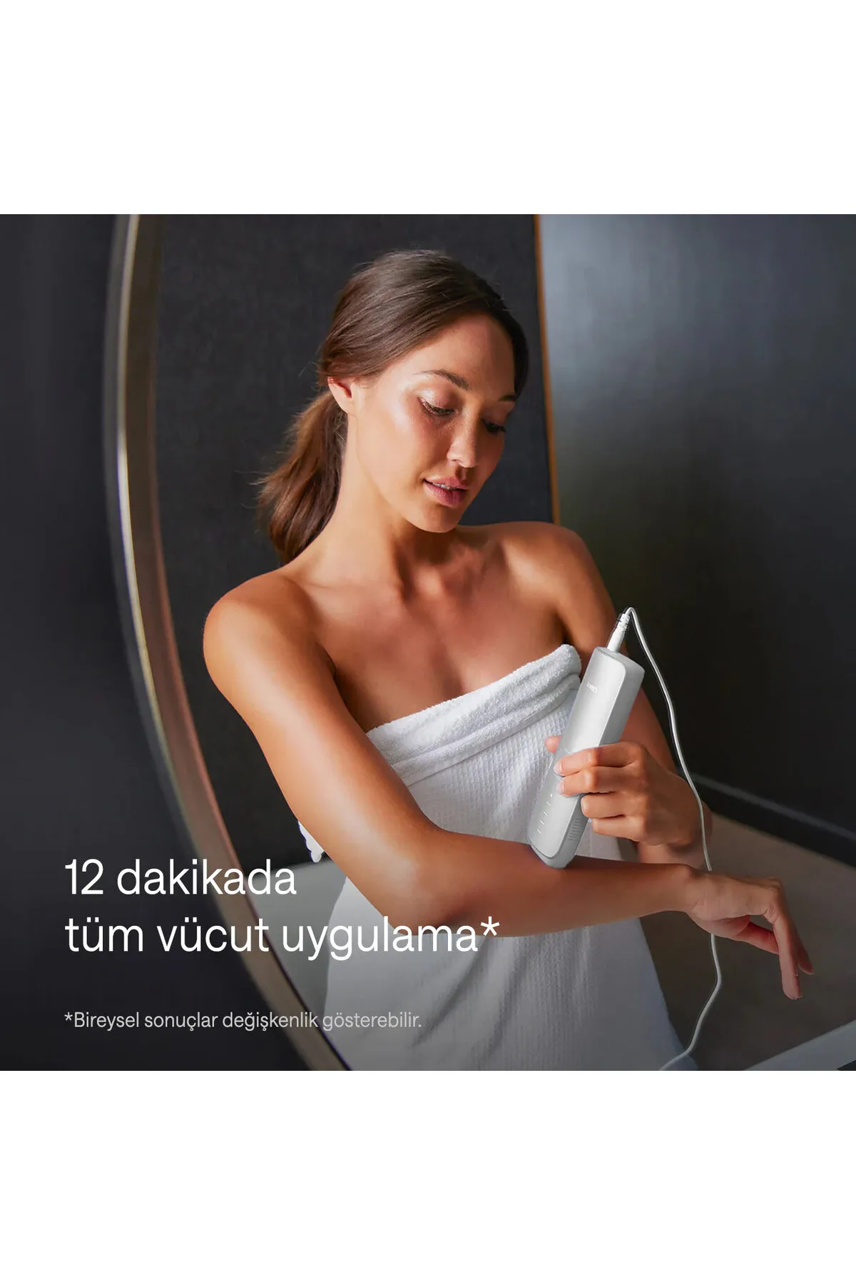 Havlu içindeki bir kadın, kolunda bir epilasyon cihazı kullanıyor.