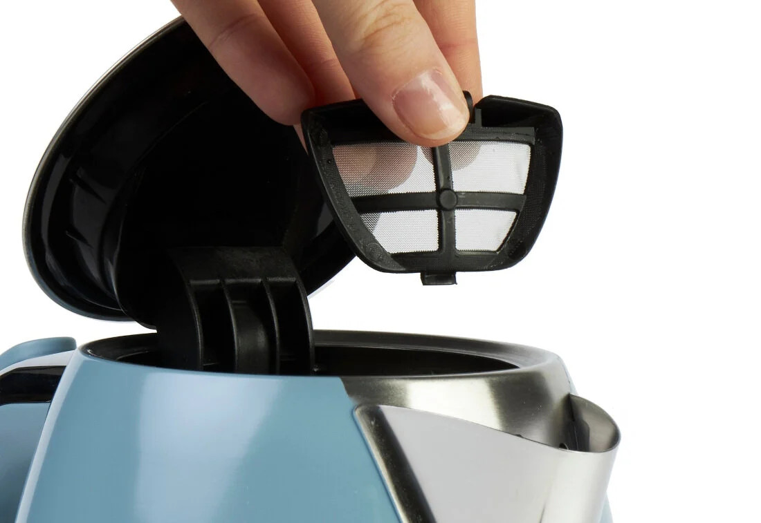 Ręka wyjmująca filtr z niebieskiego czajnika Haden.