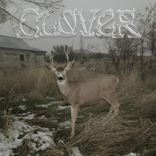 Hirsch auf einem Feld mit Haus im Hintergrund, Text: Clover.