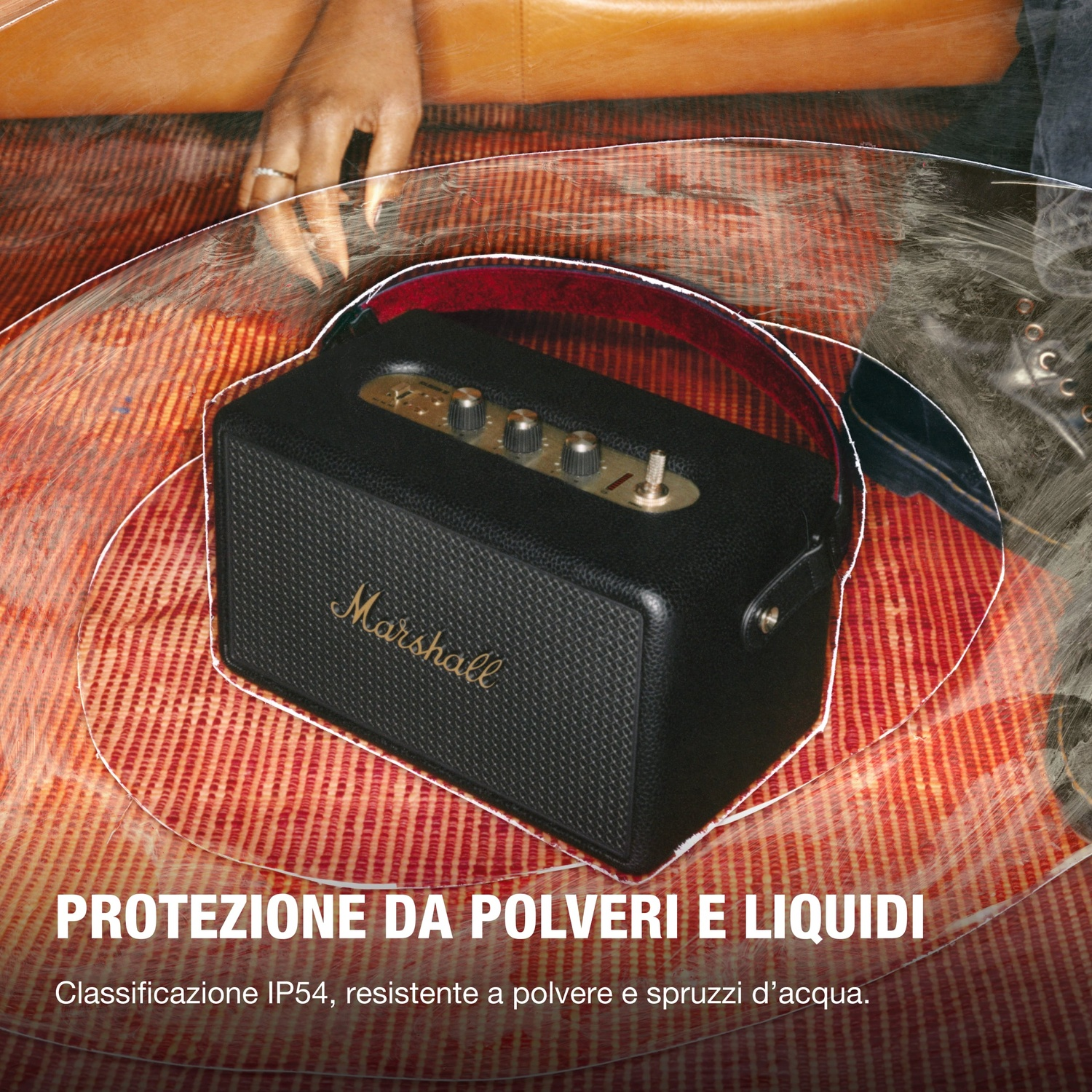 Altoparlante Marshall su tappeto rosso, con testo 'PROTEZIONE DA POLVERI E LIQUIDI'.