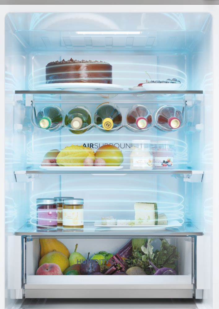Kühlschrankinnenraum mit Kuchen, Weinflaschen, Obst, Gläsern und frischen Produkten. Air Surround-Effekt sichtbar.
