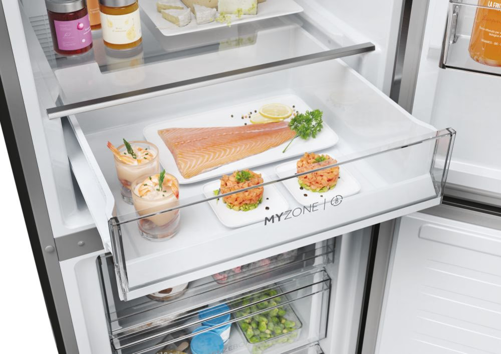 Cassetto del frigorifero con alimenti. Cocktail di gamberi, salmone e piatti preparati sono ben disposti.