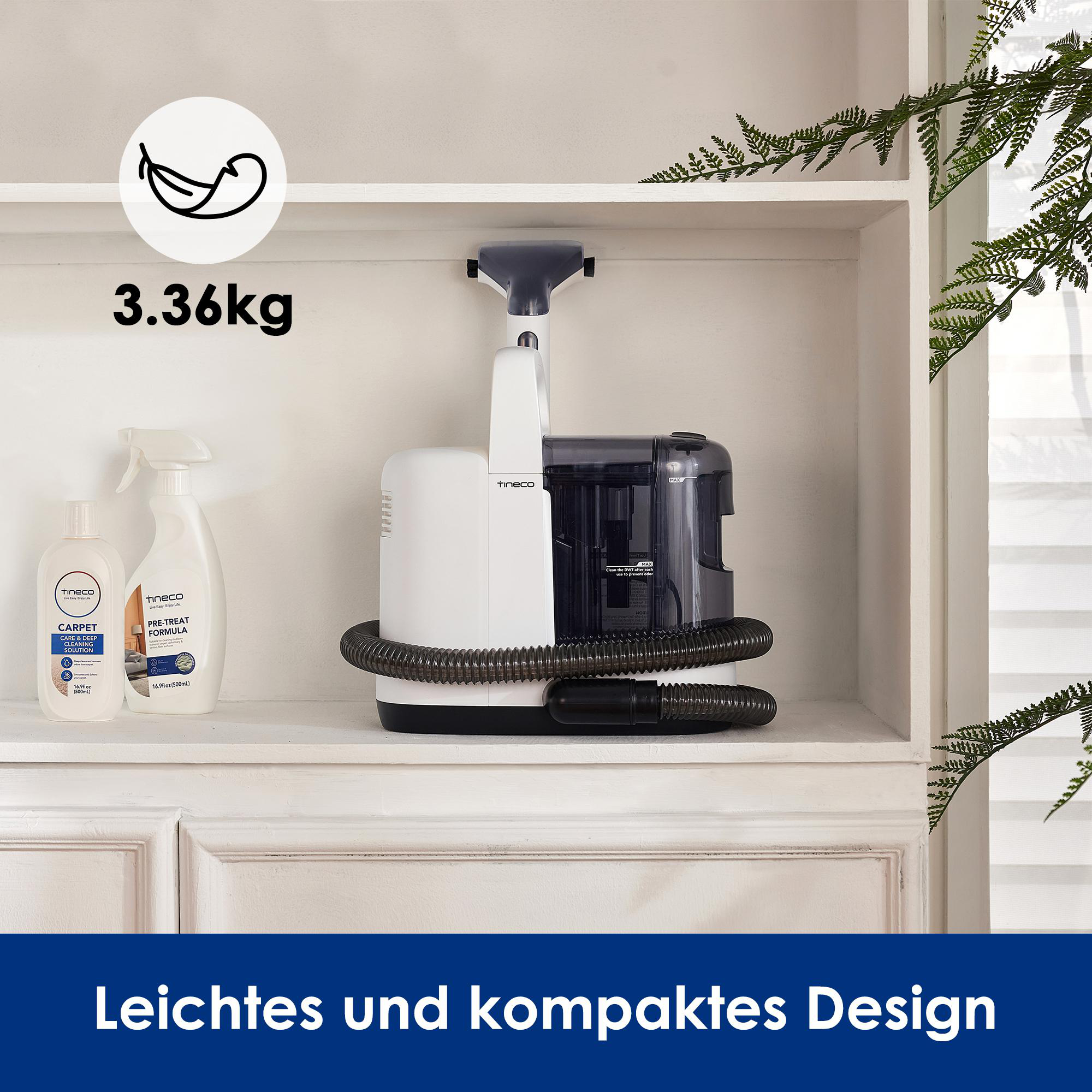 Weiß-schwarze Reinigungsmaschine mit zwei Flaschen auf weißem Schrank, grüne Pflanze.