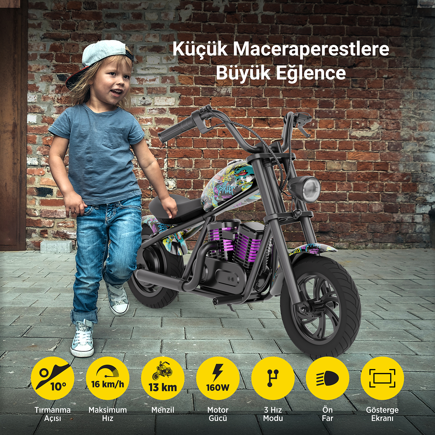 Bir çocuk, tuğla duvar arka planlı bir oyuncak motosikletin yanında duruyor.