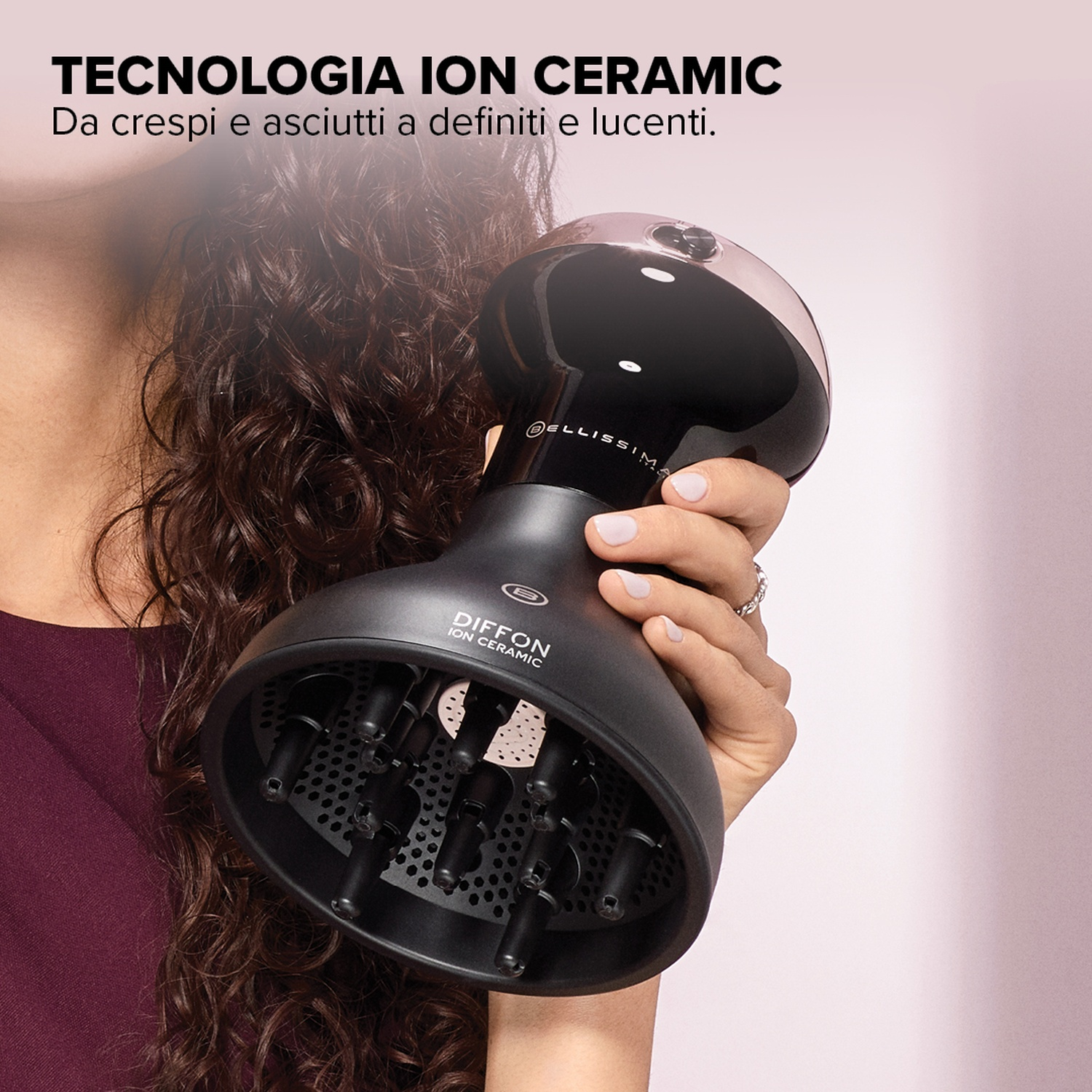 Primo piano di un diffusore nero per capelli tenuto da una donna. Testo sulla tecnologia ionica ceramica.