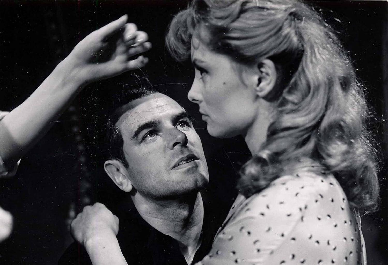 Zwei Männer und eine Frau in einem Schwarz-Weiß-Foto. Ein Mann tröstet einen anderen.