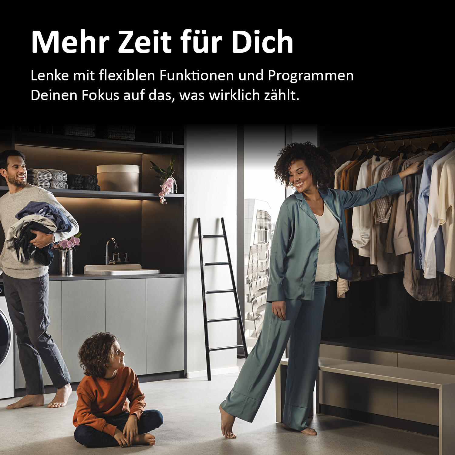 Familie in einem modernen Waschraum. Mann trägt Kleidung, Kind sitzt, Frau lächelt am Kleiderständer.
