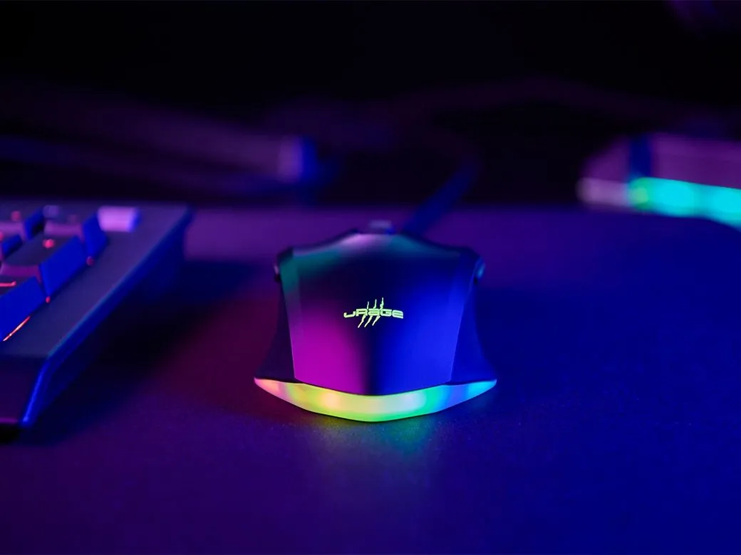 Neonfényes gamer egér. Billentyűzet balra. Sötét háttér színes neonfénnyel.