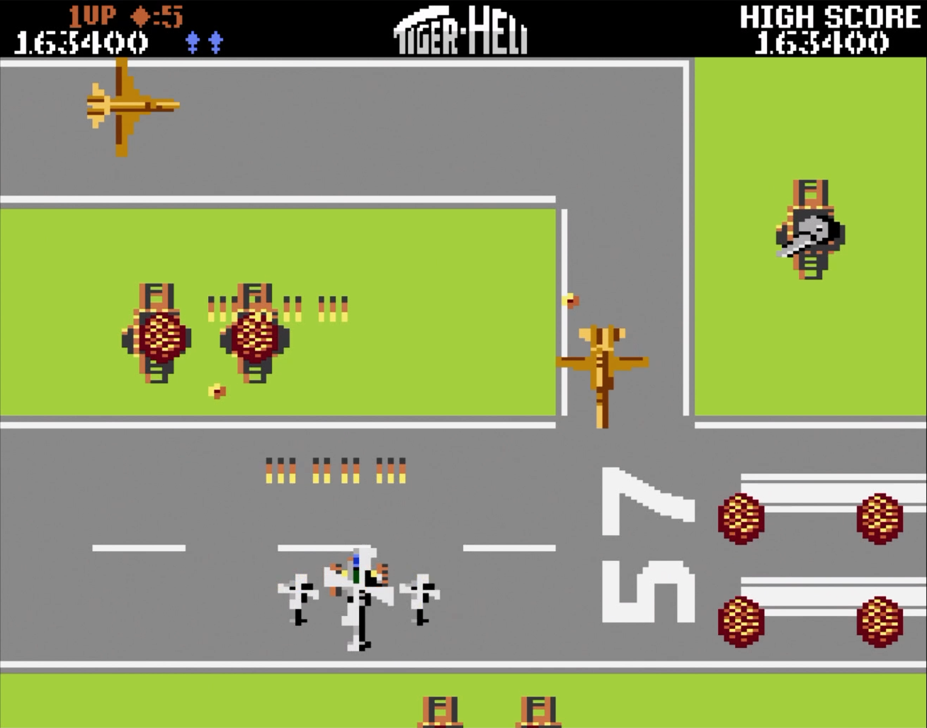Un jeu d'hélicoptère pixélisé. Un hélicoptère vole au-dessus d'un champ vert avec d'autres objets.