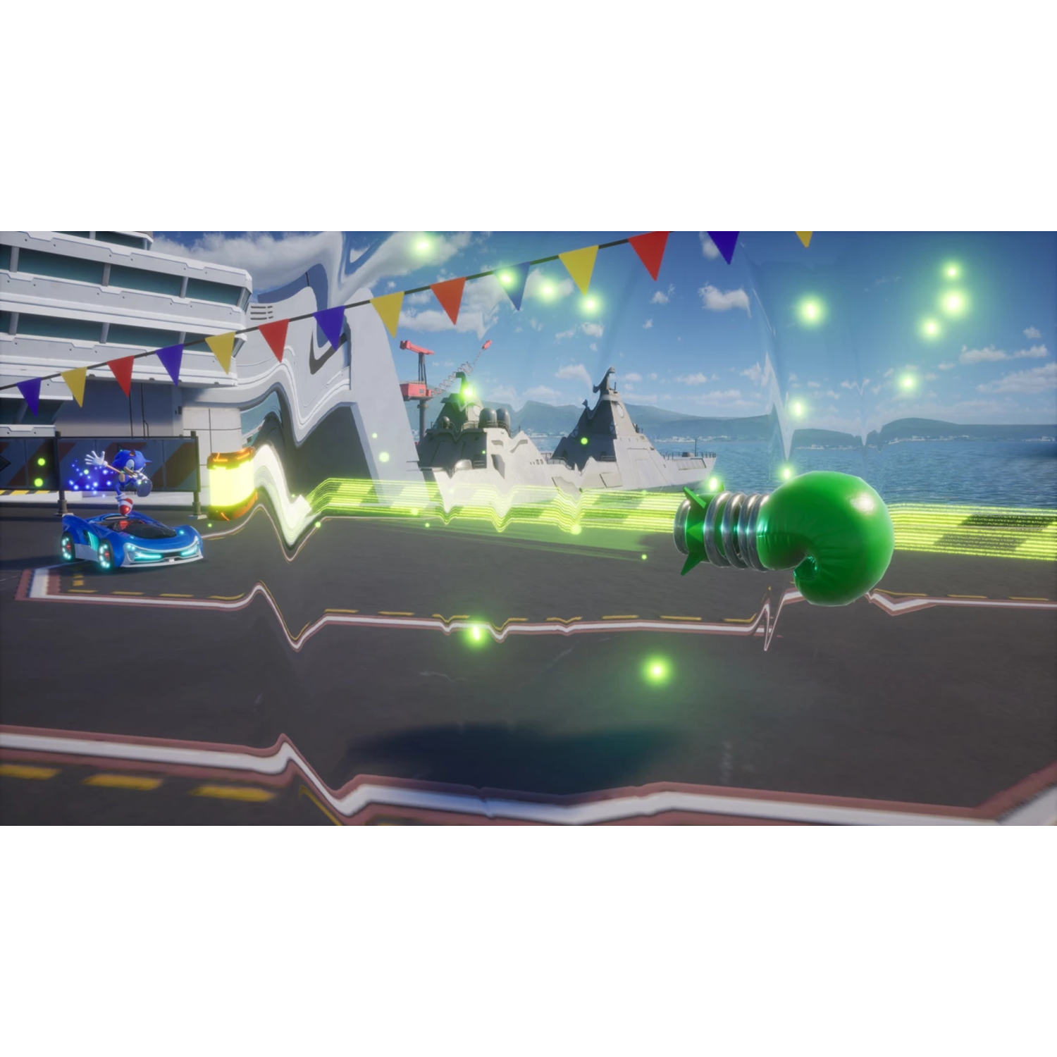 Sonic in a blue car racing on a track with a lightbulb structure and flags in the background.