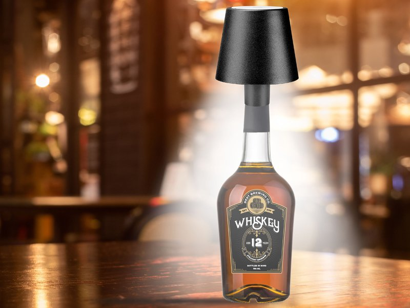 Whiskey-palack, lámpaburával. Fa asztalon, homályos hátterű bárban.