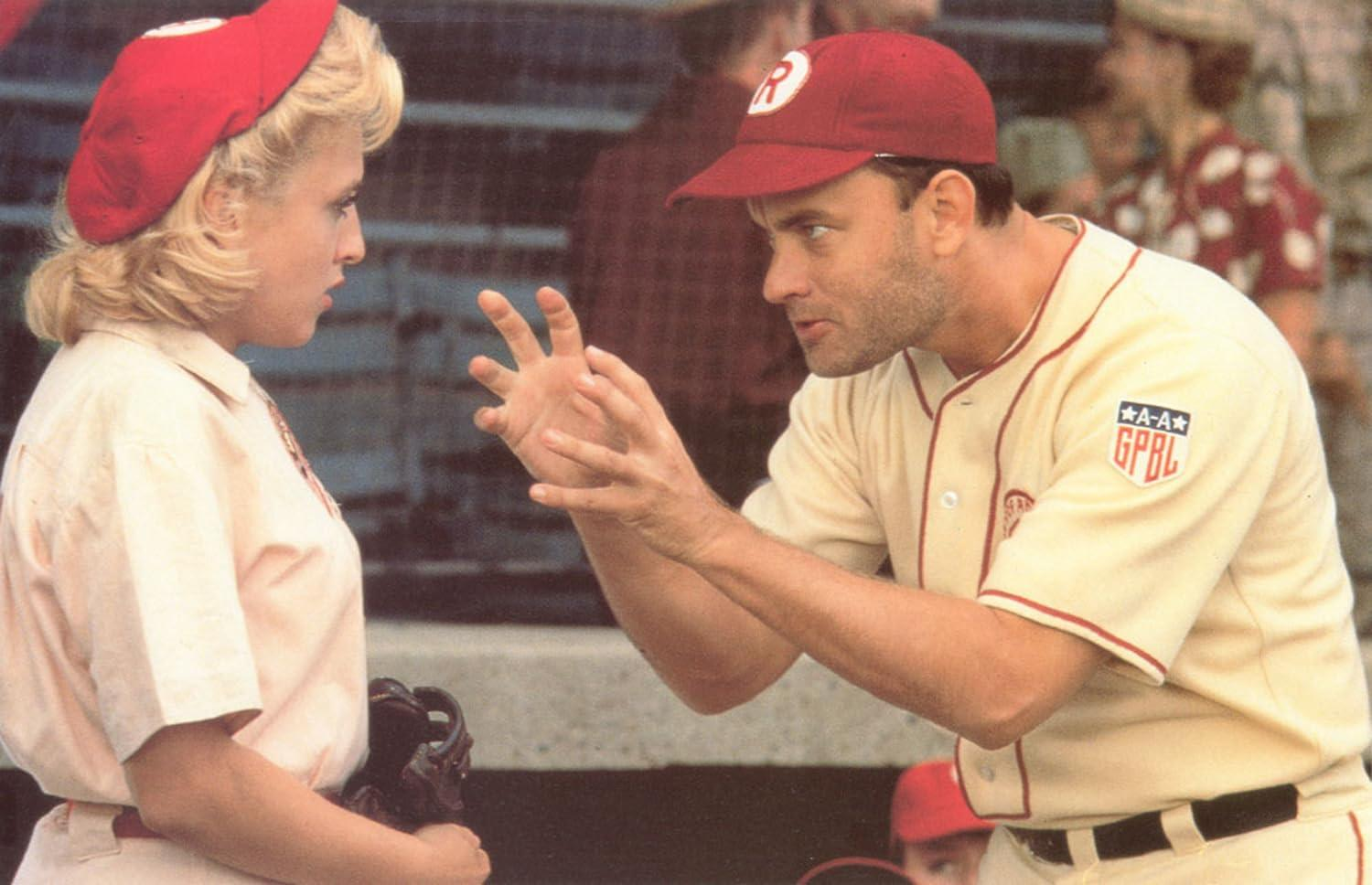 Tom Hanks spricht mit einer Baseballspielerin auf dem Baseballfeld.