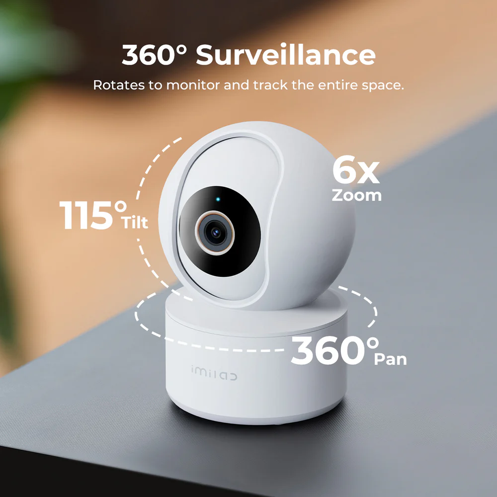 Fehér biztonsági kamera az asztalon. Szöveg: 360°-os megfigyelés, 115°-os dőlés, 6x zoom és 360°-os pásztázás kiemelve.