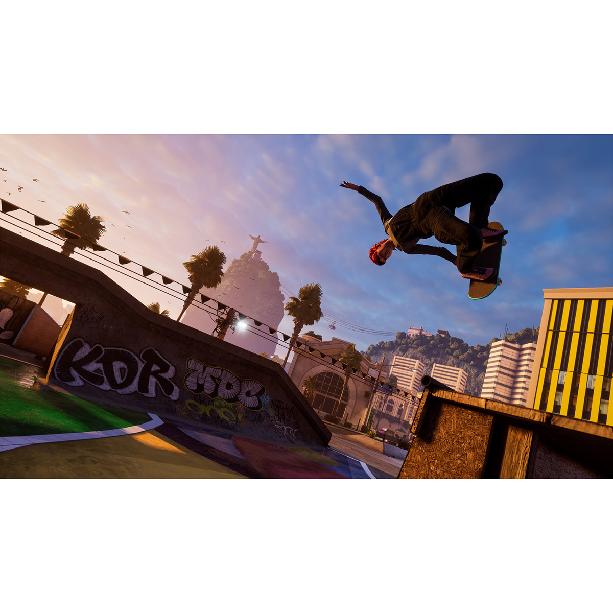 Un skater realiza un truco en el aire. El fondo presenta un paisaje urbano con palmeras y una estatua en una montaña.