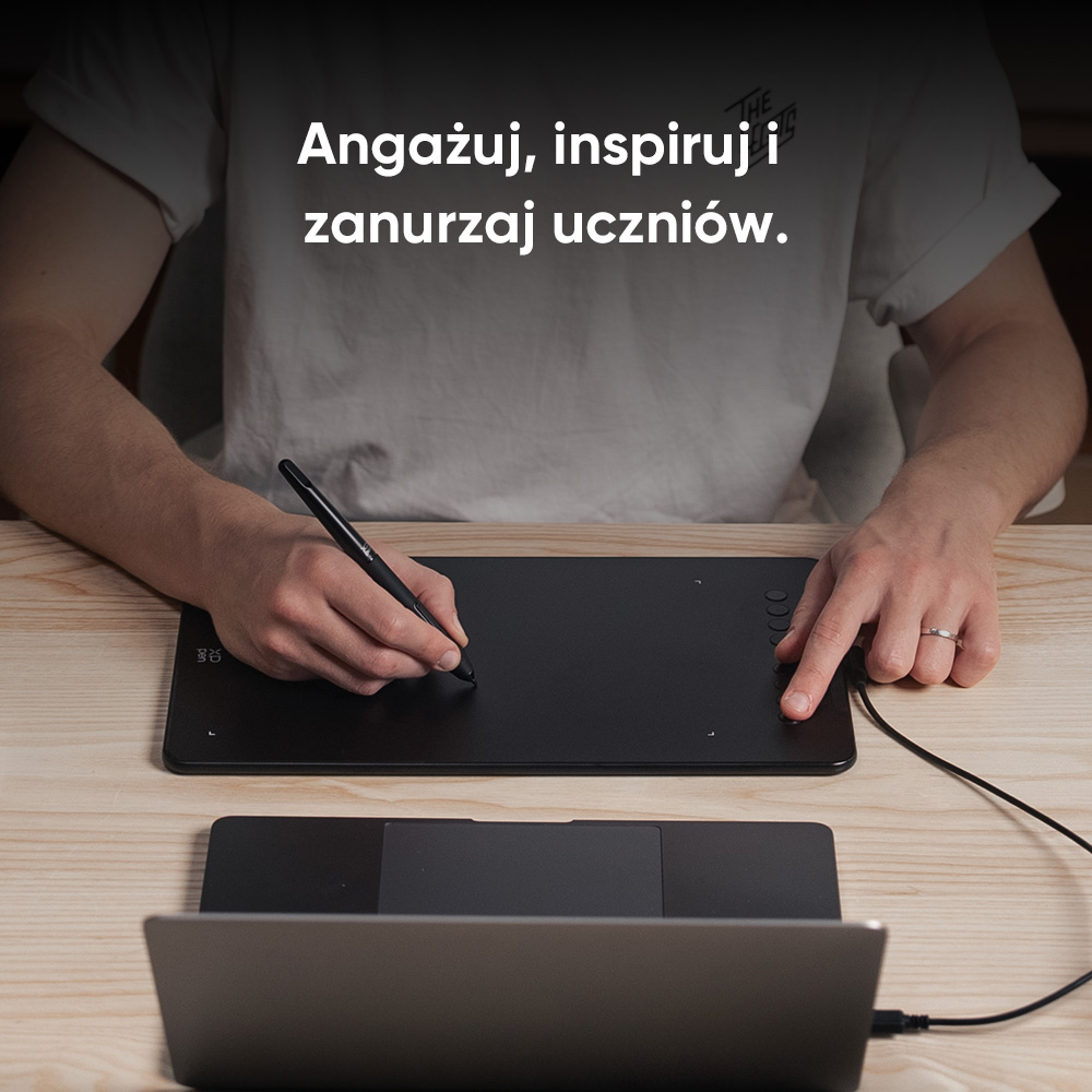 Osoba używająca czarnego tabletu z rysikiem, podłączonego do laptopa.