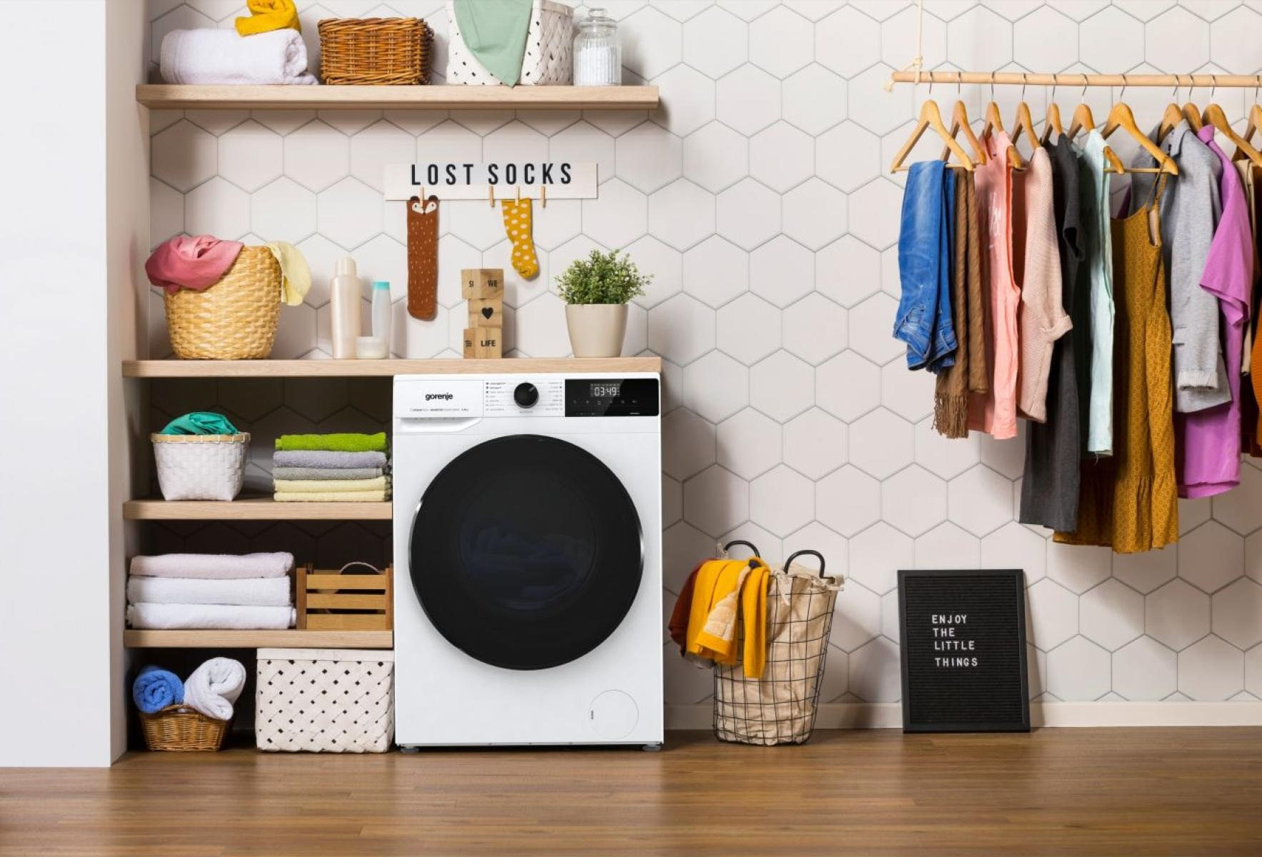 Scena pralni z pralką, półkami i ubraniami.