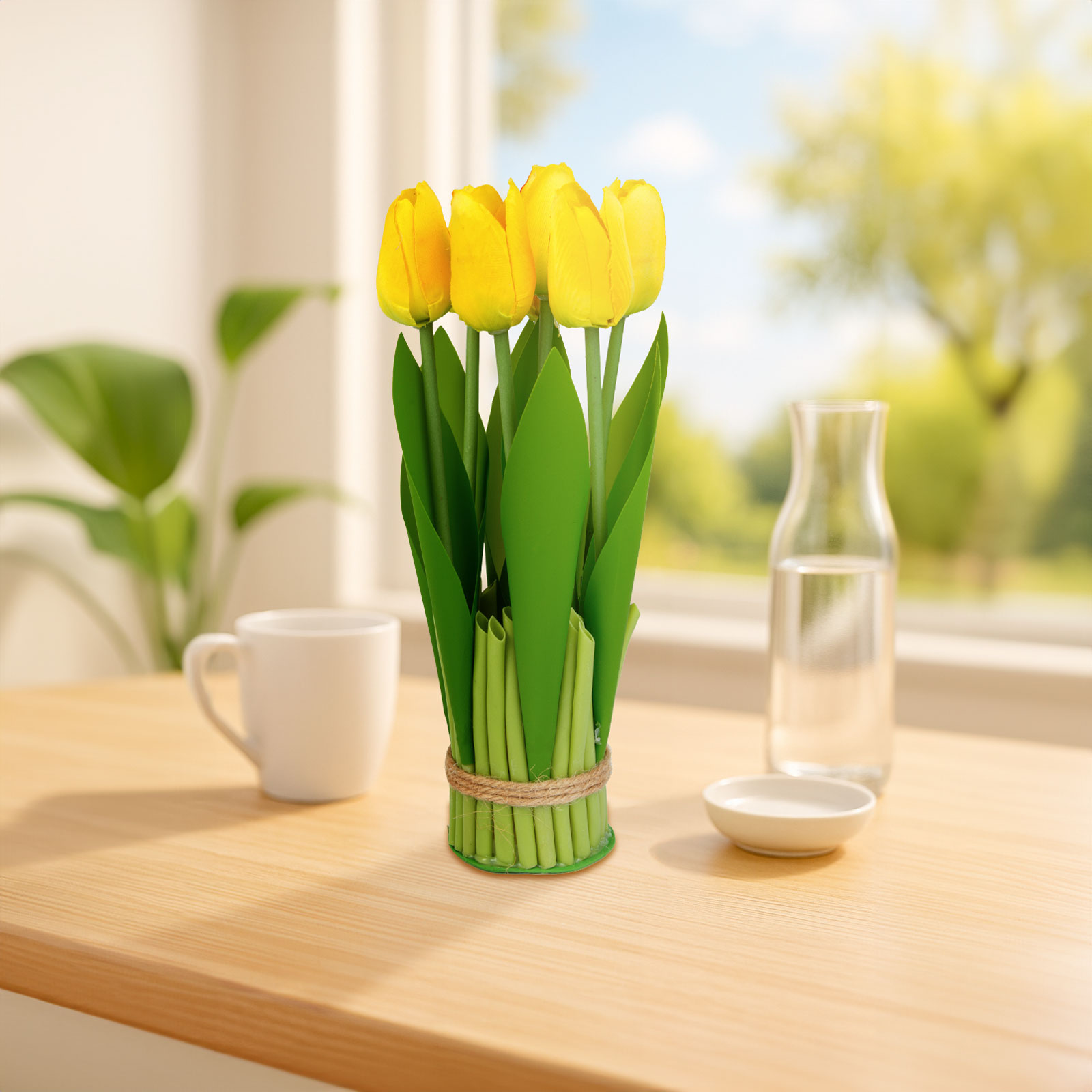 Sárga tulipánok zöld vázában az asztalon, ablak, csésze és vízkancsó a háttérben.