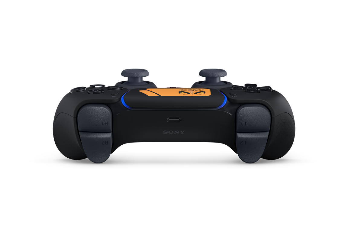 Widok z tyłu kontrolera Playstation 5. Czarno-pomarańczowy design z widocznymi gałkami i przyciskami.