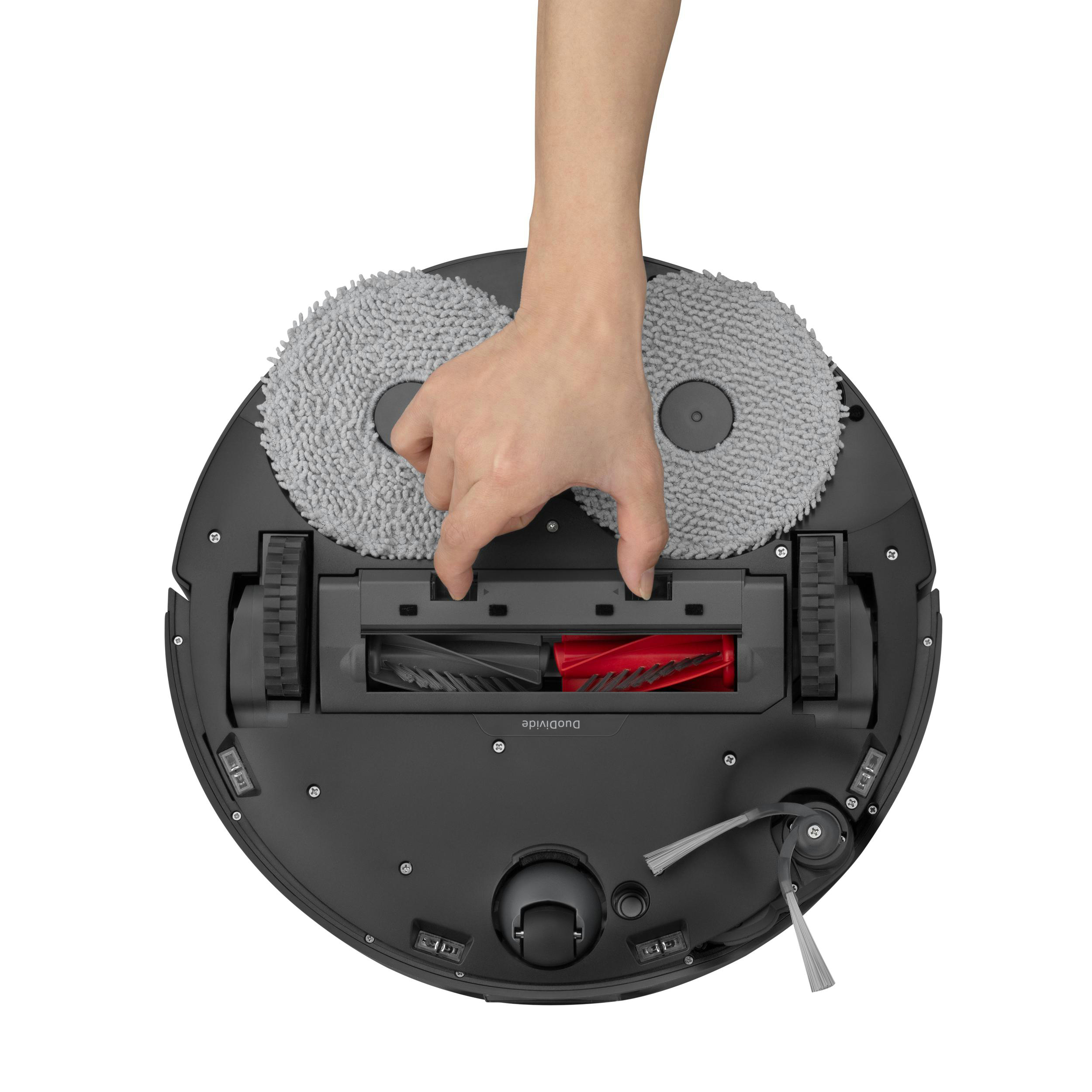 Eine Hand, die die Bürste von einem Roboter-Staubsauger entfernt.