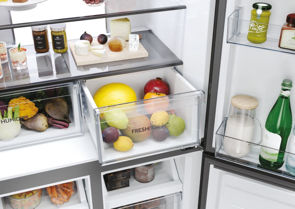 Gros plan du tiroir 'Fresh Box' avec fruits et 'Humidity Zone' avec légumes dans un réfrigérateur.