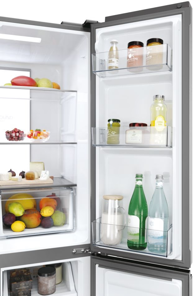 Intérieur d'un réfrigérateur Haier avec étagères contenant bocaux, bouteilles et récipients alimentaires.