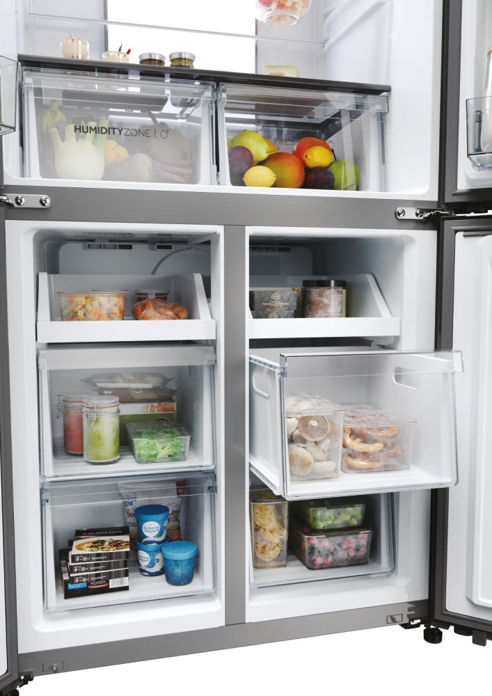 Réfrigérateur Haier ouvert avec divers contenants alimentaires et surgelés dans les tiroirs.