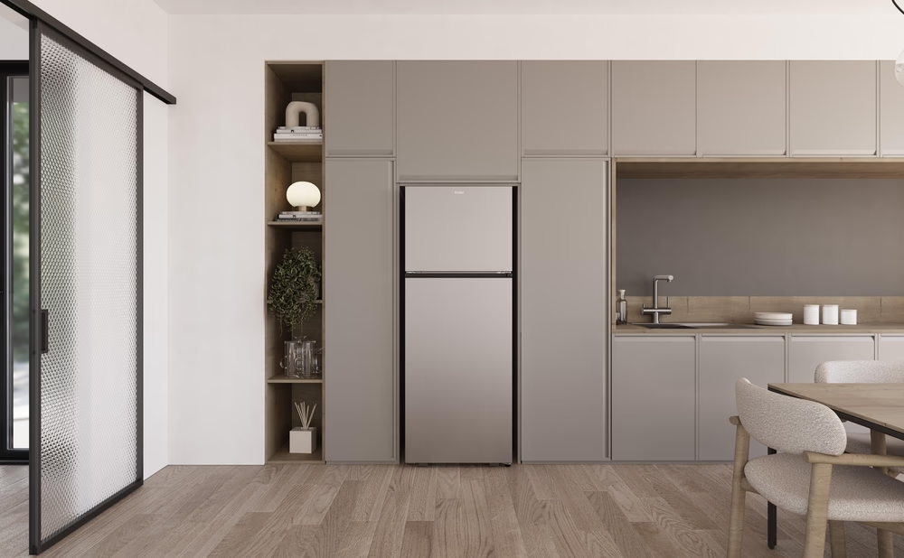 Una cucina moderna con un frigorifero Haier, pavimento in legno e mobili dai colori chiari. Design pulito.