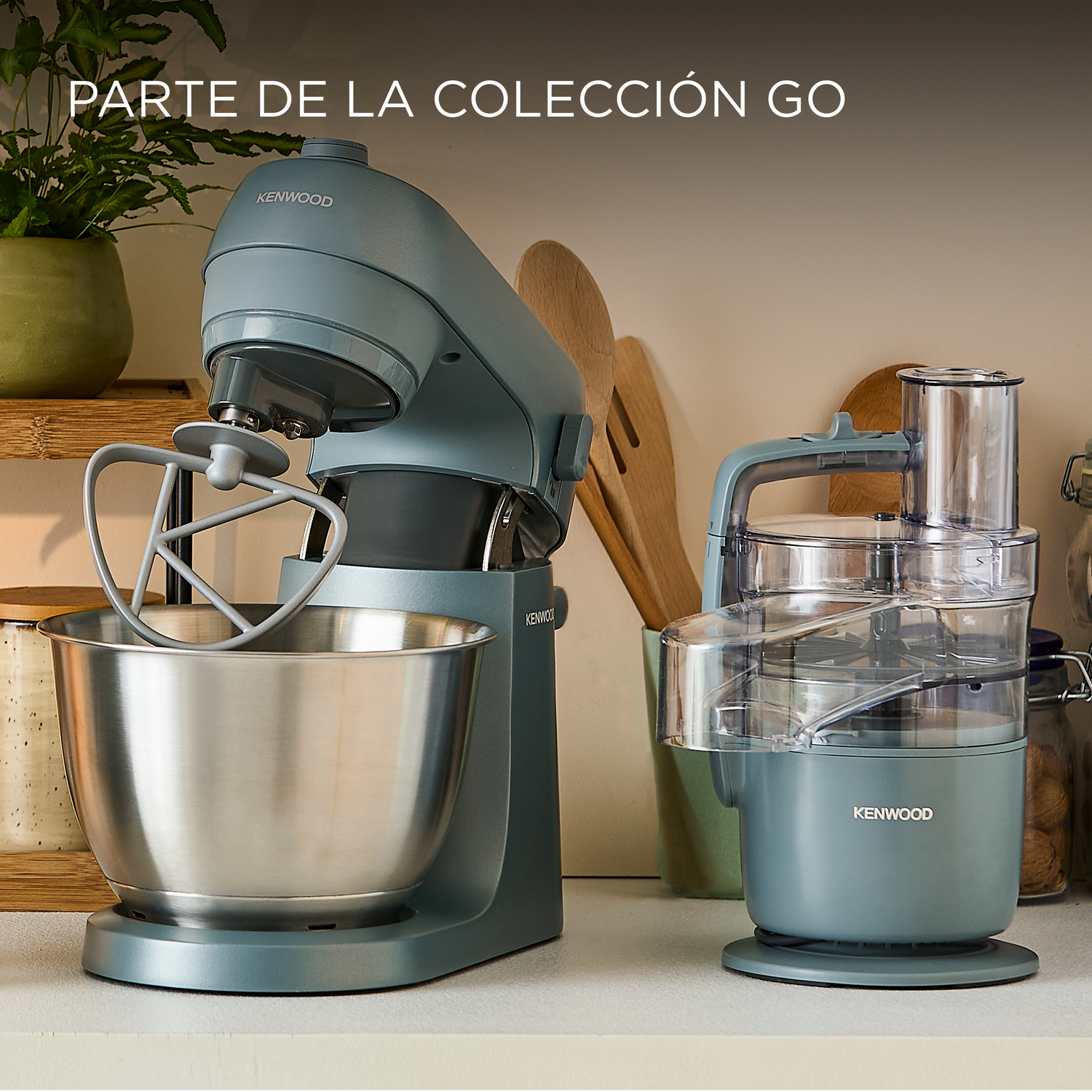 Dos electrodomésticos de cocina azules. Una batidora Kenwood y un procesador de alimentos, ambos sobre una encimera blanca.