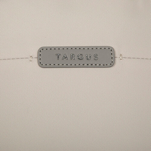 Primer plano del logotipo gris Targus en una bolsa beige. El logotipo está cosido en un parche gris.