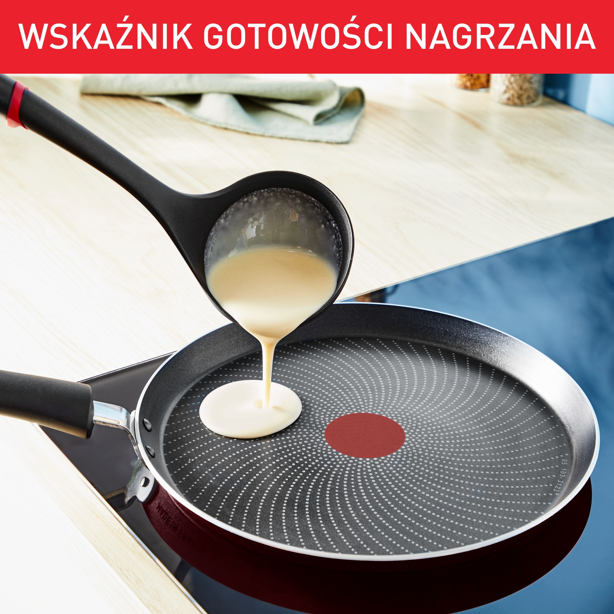 Chochla wlewa ciasto do patelni. Formuje się naleśnik. Patelnia stoi na kuchence.