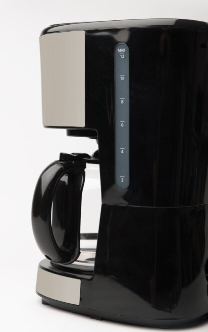 Widok z boku czarnego ekspresu do kawy, pokazujący oznaczenia poziomu wody, z czarnym uchwytem i beżowymi akcentami.