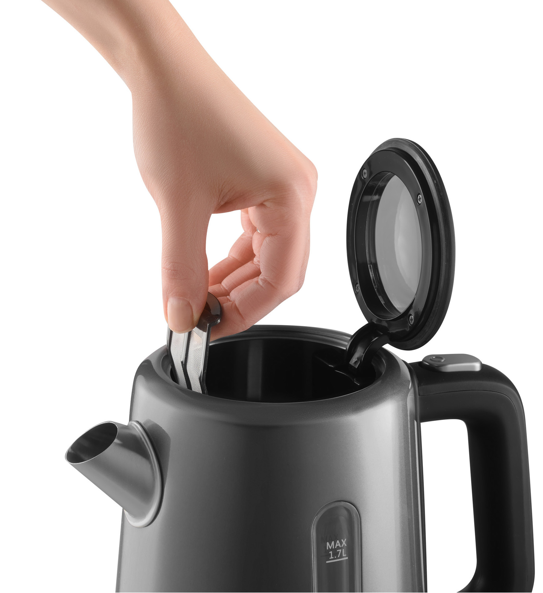 Ręka umieszcza filtr w czarnym czajniku. Czajnik ma otwartą pokrywę i wskaźnik poziomu wody.