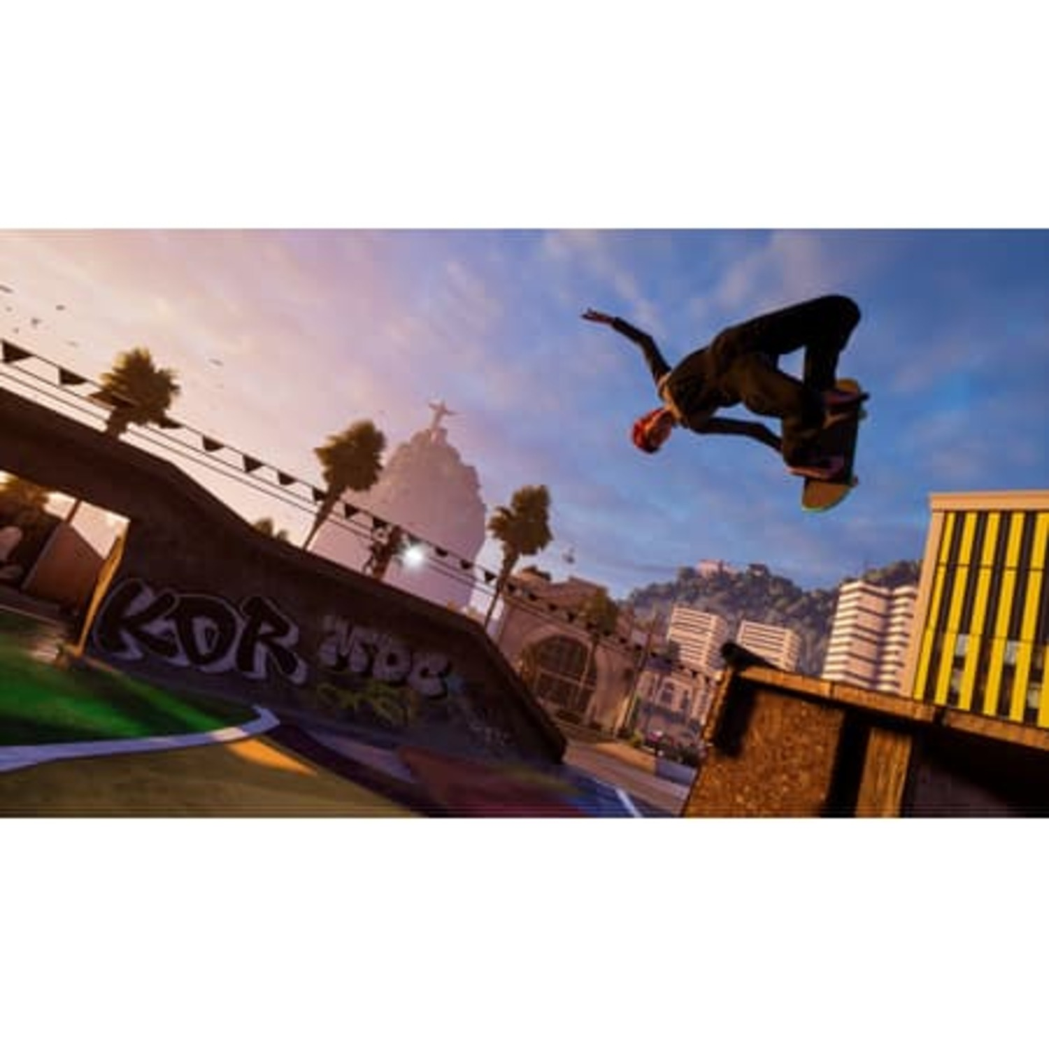 Skateboarder doet een truc in de lucht. Graffiti en gebouwen op de achtergrond bij zonsondergang.