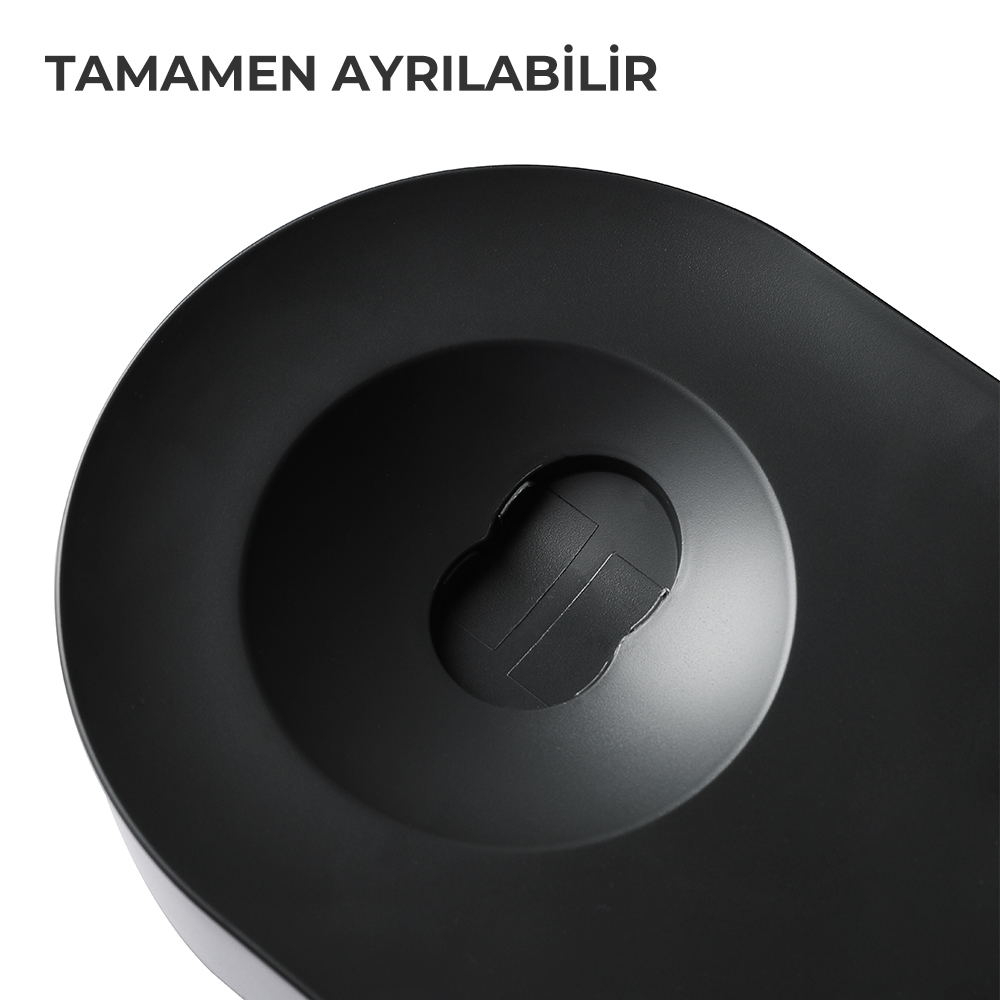 Merkezi anahtar deliği şeklinde bir çöküntüye sahip, siyah, dairesel bir nesnenin yakın çekimi. Yüzey mat.