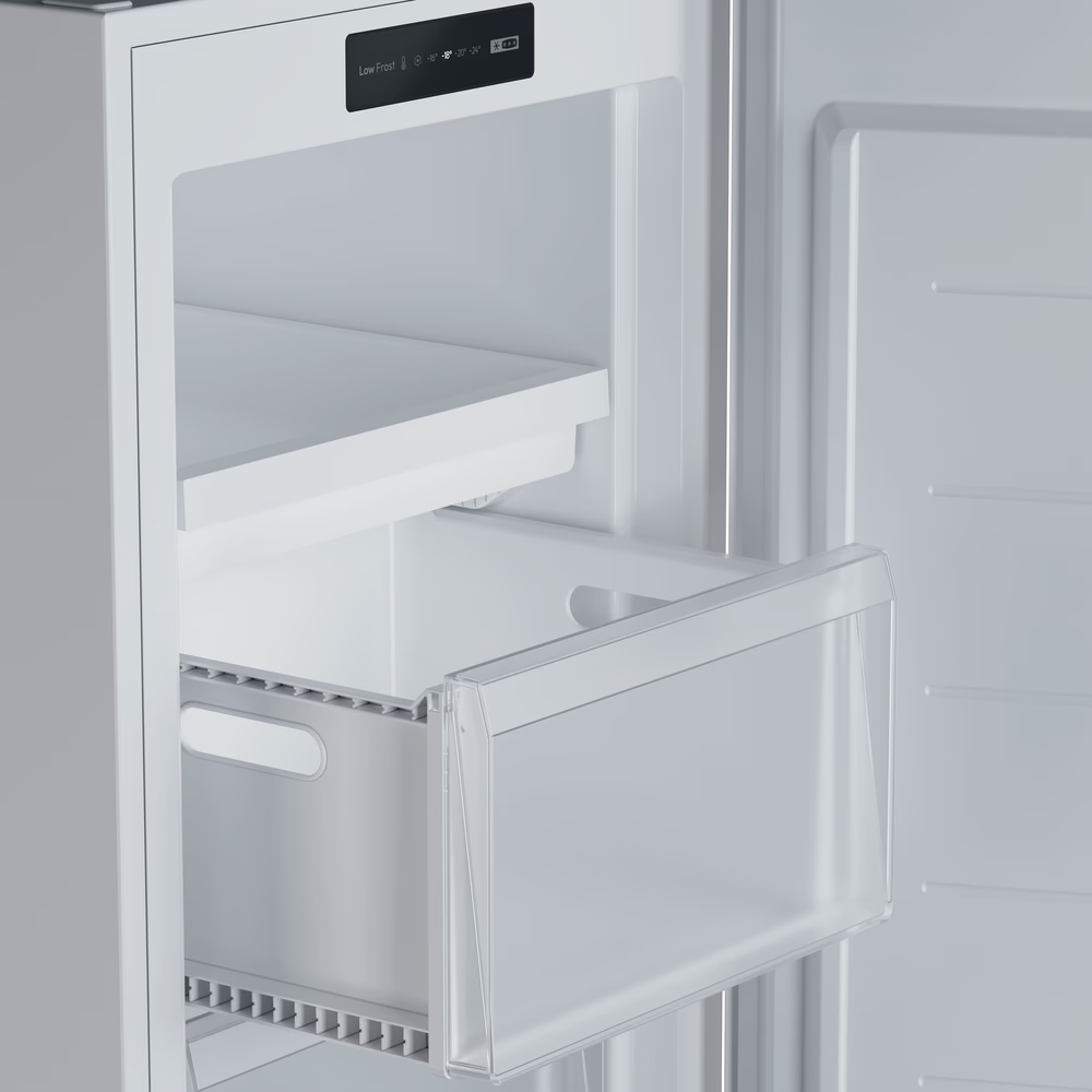 In einem weißen Kühlschrank ist eine teilweise herausgezogene Schublade zu sehen. Ein Regal darüber und die Tür sind ebenfalls sichtbar.