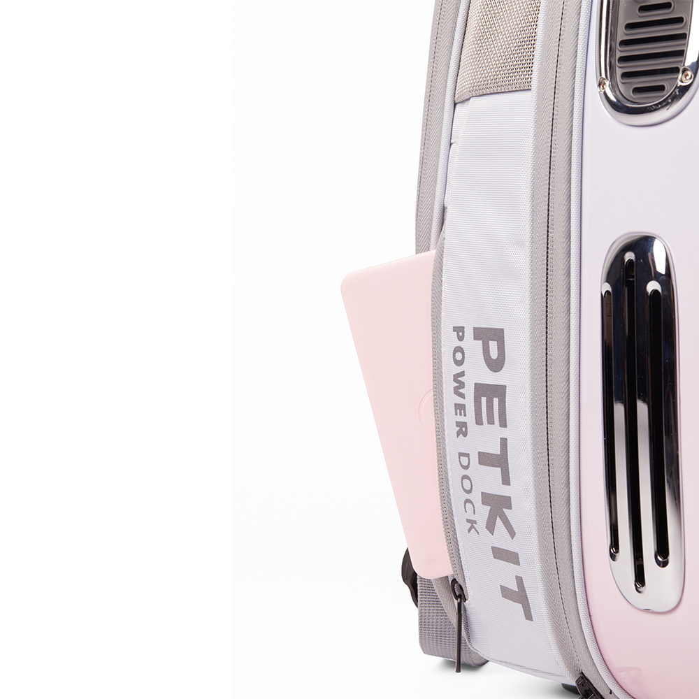 Pembe ve gri bir PETKIT Power Dock evcil hayvan taşıyıcısı. Yan cebinde pembe bir telefon var. Beyaz zemin.