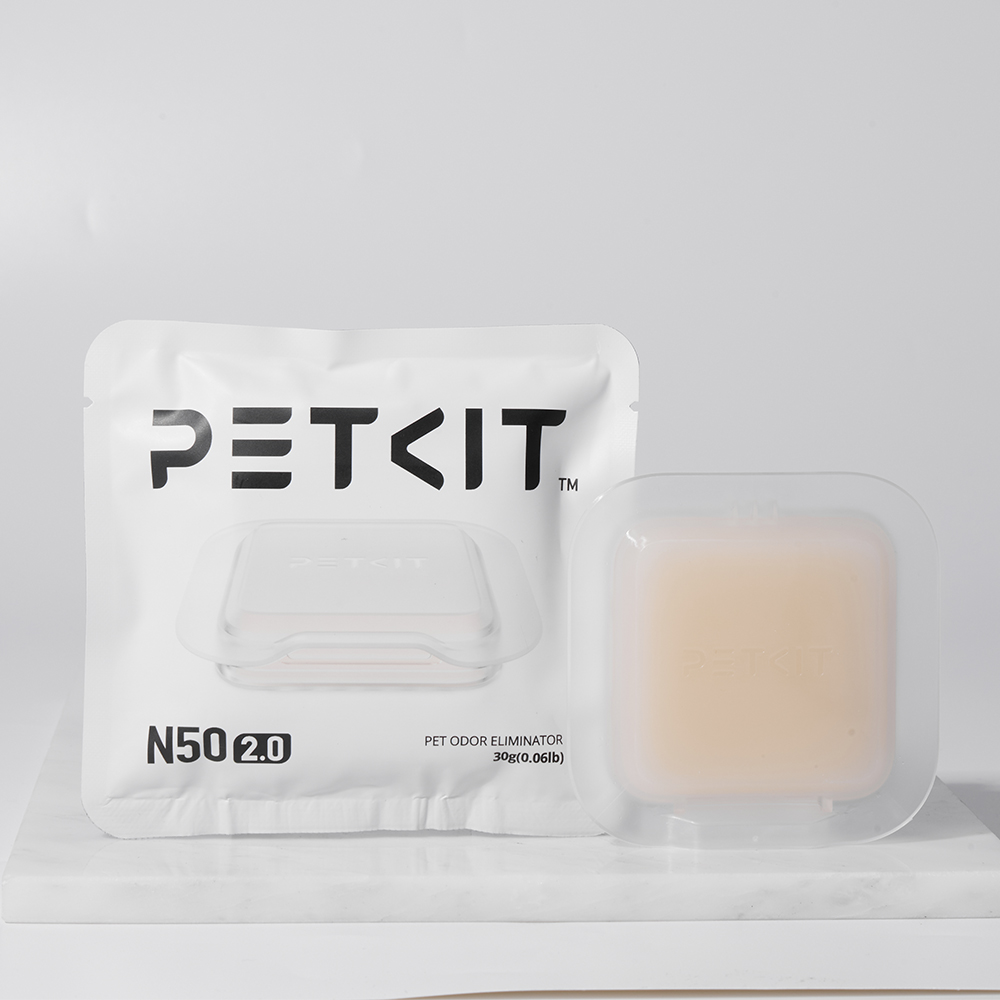 Ayrı, şeffaf bir kap ile beyaz PETKIT koku giderici paketi. Paketteki metin 'PETKIT N50 2.0' yazıyor.