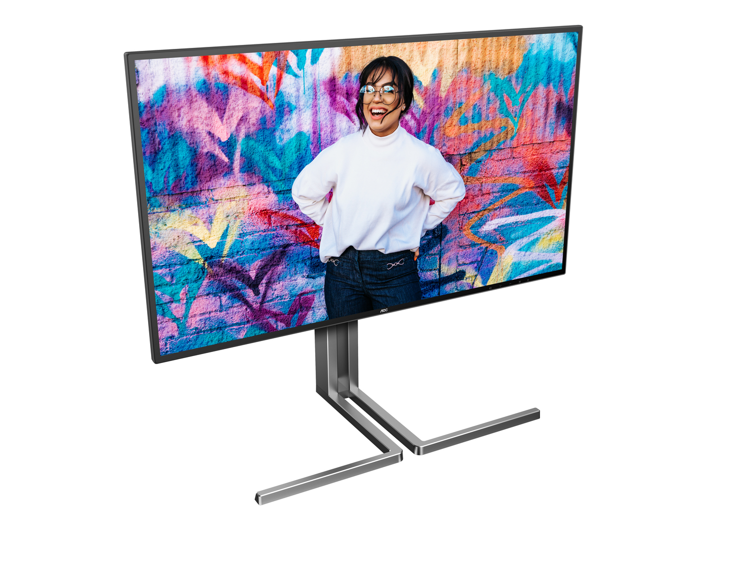 El monitor muestra a una mujer sonriendo frente a una colorida pared de graffiti. El monitor tiene un soporte plateado.