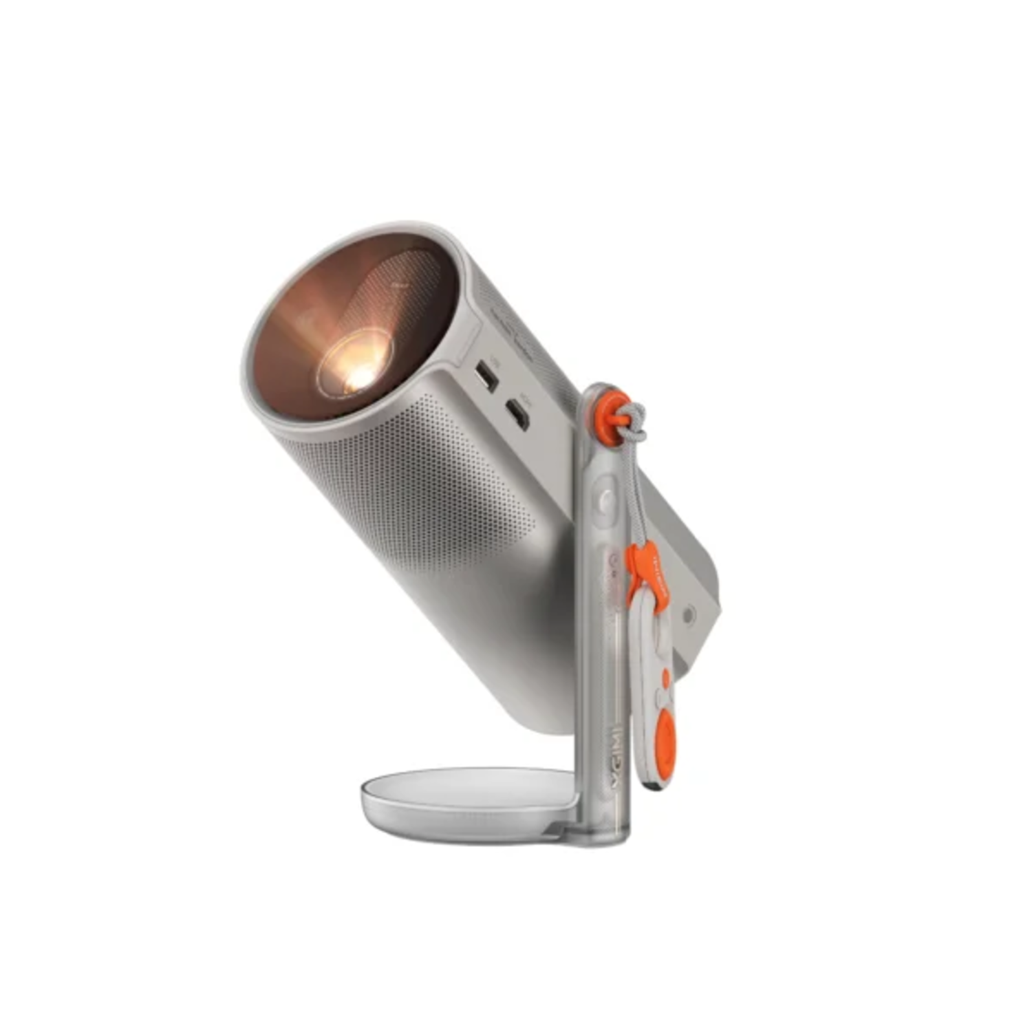 Un projecteur argenté avec une télécommande orange et blanche est positionné sur une surface blanche. Le projecteur émet de la lumière.