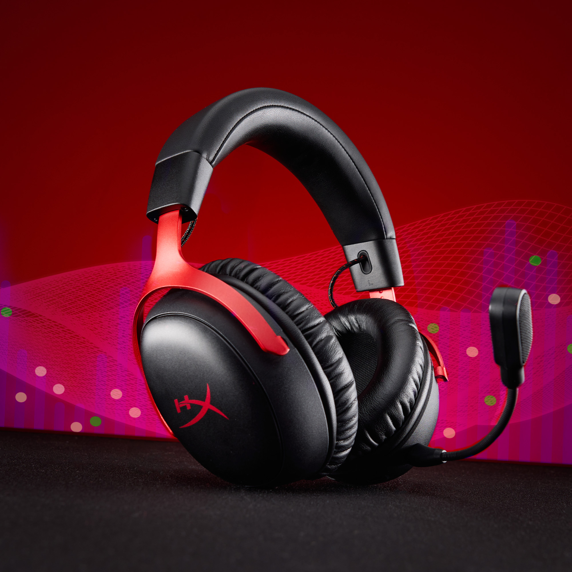 Schwarzes und rotes Gaming-Headset auf schwarzem Untergrund mit rotem und lila Hintergrund.