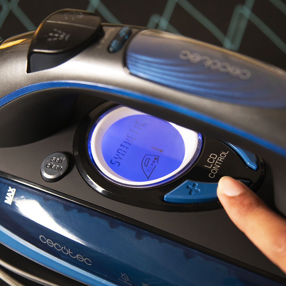 Zbliżenie żelazka z niebieskim ekranem LCD wyświetlającym 'syntetyczne'. Palec naciska przycisk.