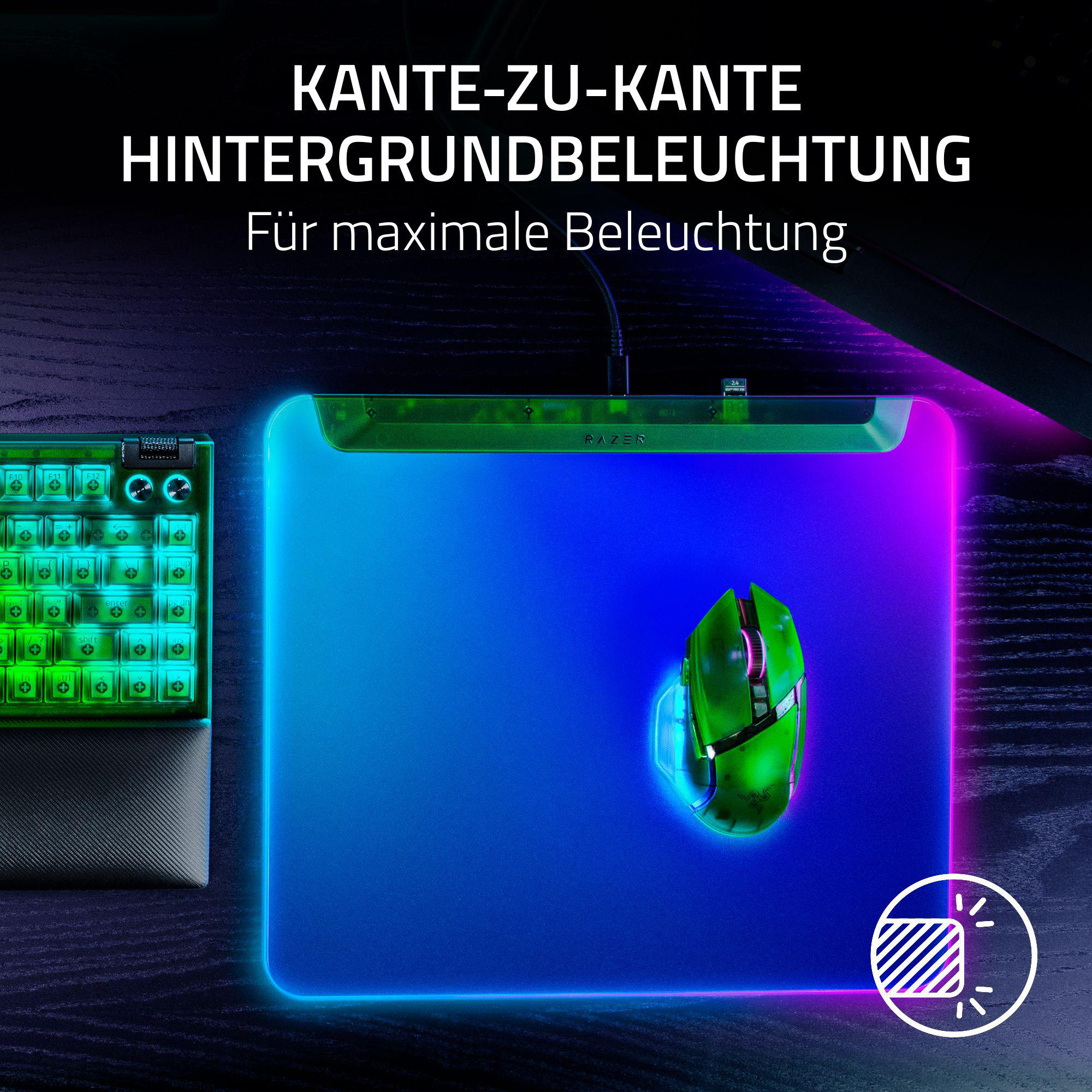 Gaming-Setup mit Tastatur, Maus und Mauspad, alle mit Neonfarben hinterleuchtet, auf dunkler Holzoberfläche.