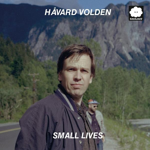 Albumcover von Håvard Volden, Titel 'Small Lives'. Mann in Jacke vor Berglandschaft. Eine weitere Person im Hintergrund.