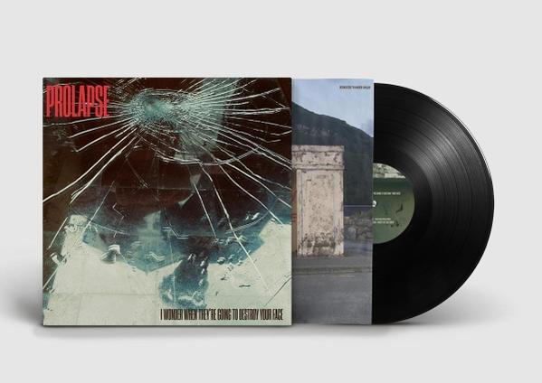 Albumcover mit zerbrochenem Glas, dem Wort 'PROLAPSE' und einer Schallplatte. Der Hintergrund zeigt ein Gebäude und einen Berg.