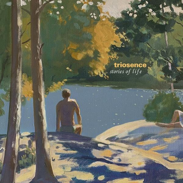 Ein Mann steht in der Nähe eines Sees, Bäume links. Gelbes und grünes Laub rechts mit dem Text 'triosence stories of life'.