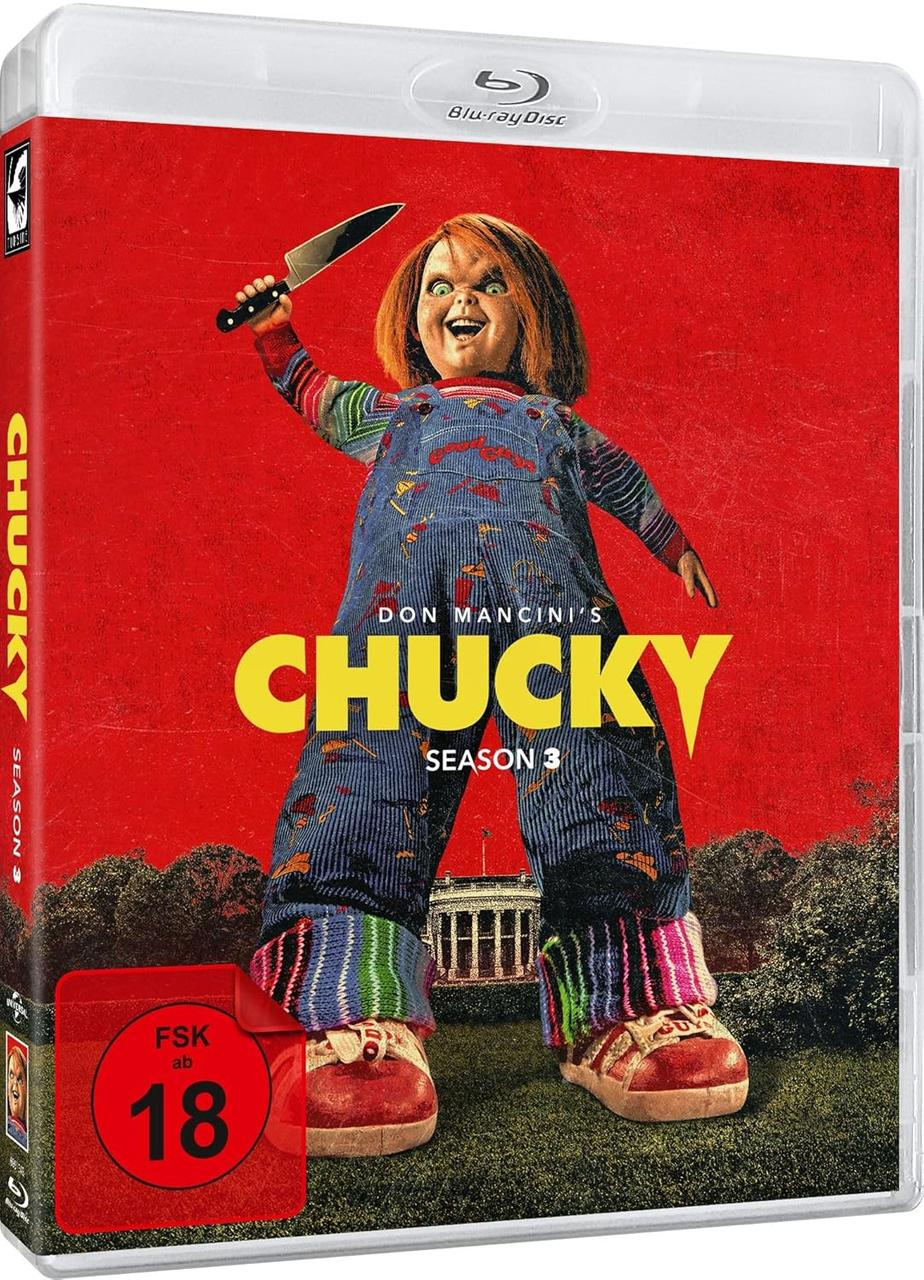 Chucky-Puppe mit Messer auf Blu-ray-Disc-Hülle. Roter Hintergrund, Chucky in Latzhose. Weißes Haus im Hintergrund. Staffel 3.